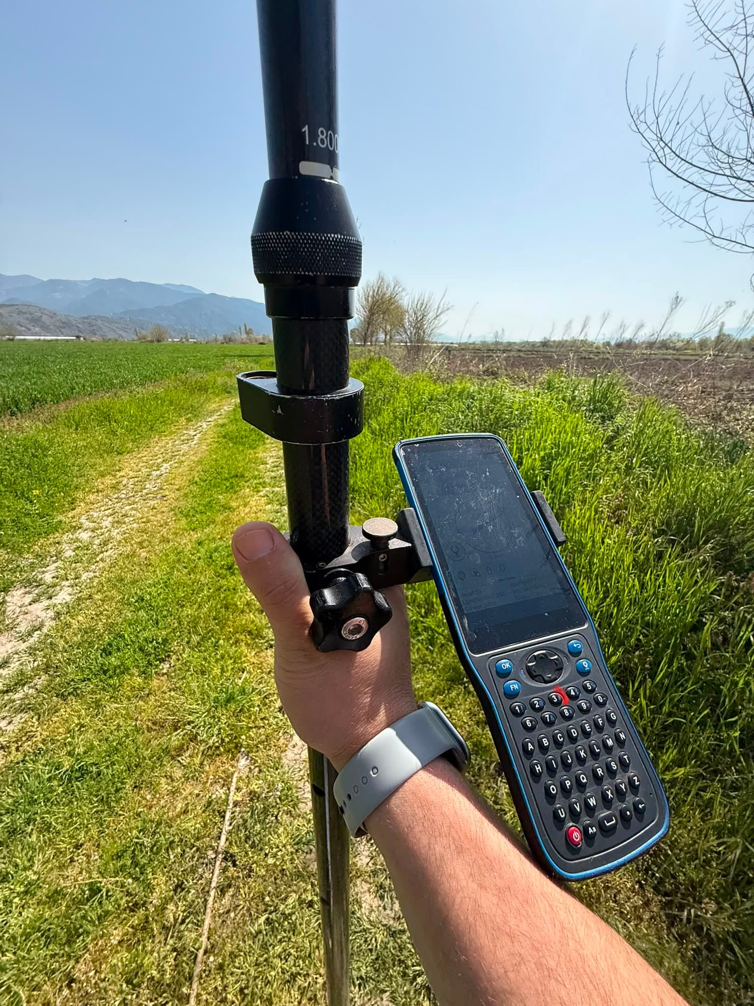 Tarım arazisinde GNSS direği ve el terminaliyle alınan nokta ölçümü